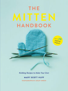 blue book cover with a partially knitted mitten on it